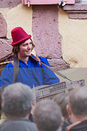 member of the Hauvoy ensemble playing the nyckelharpa in front of several people